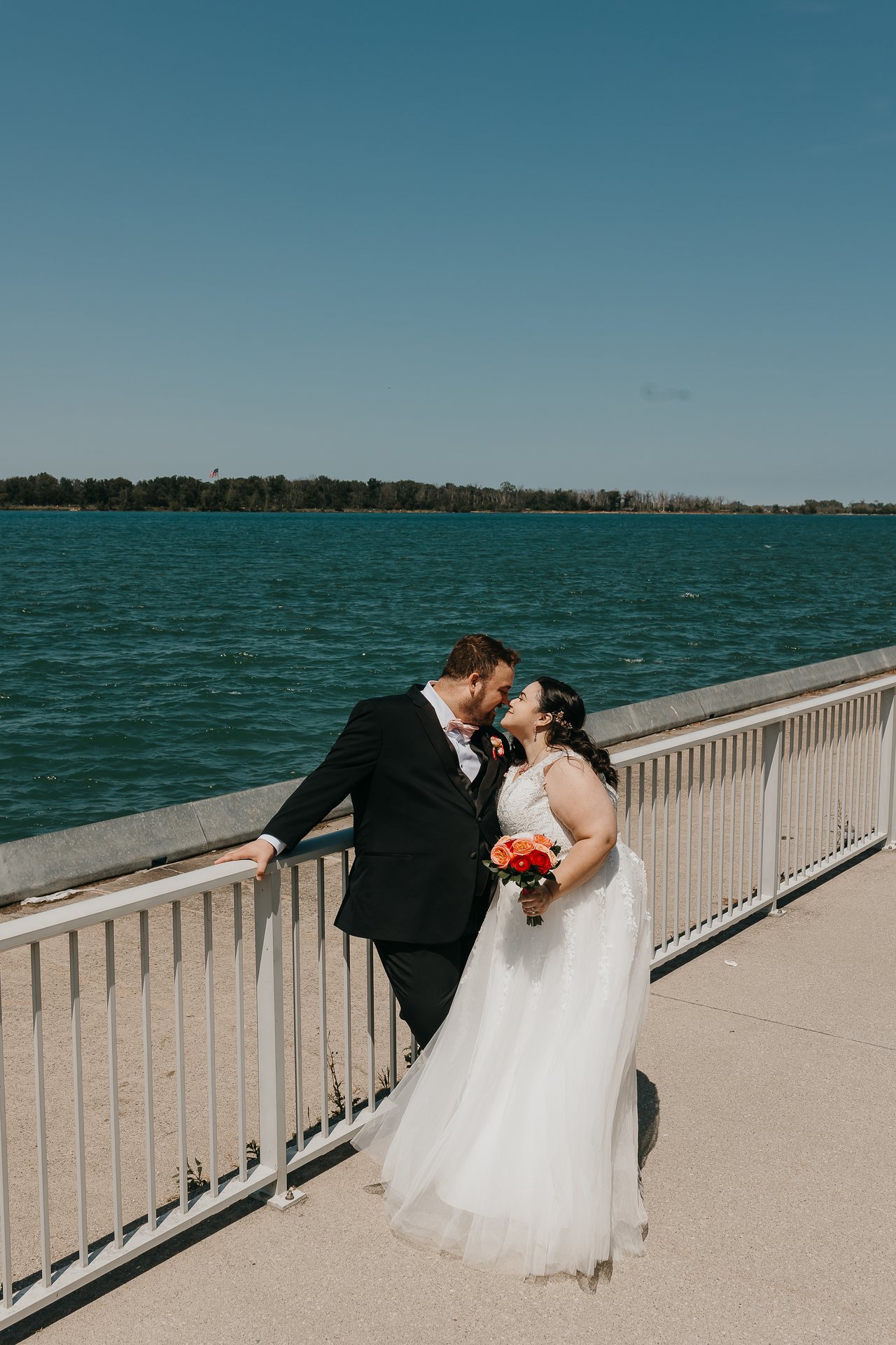 Chelsie and Greg sharing a kiss beside the waterfront railing