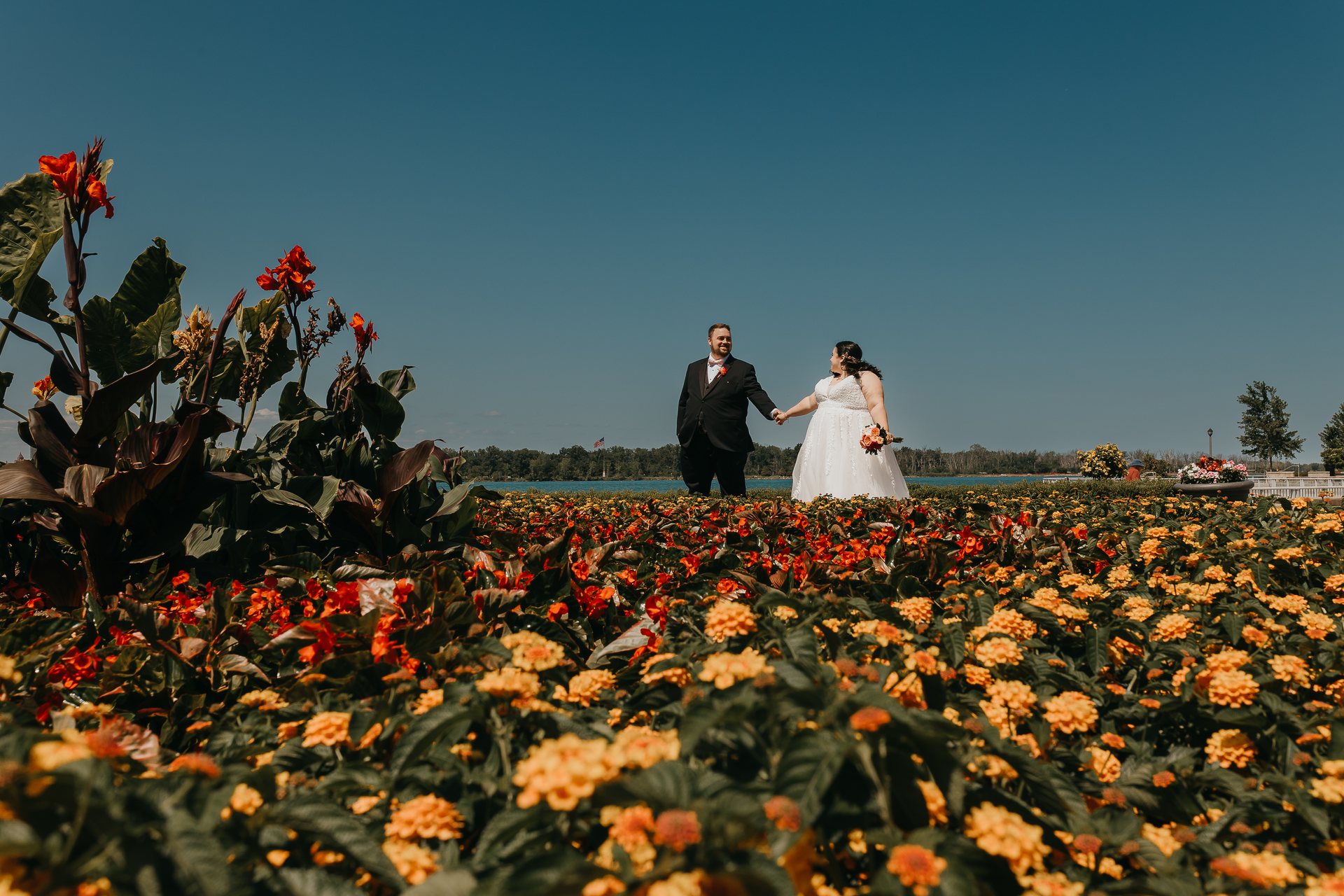 Chelsie and Greg holding hands in a flower garden