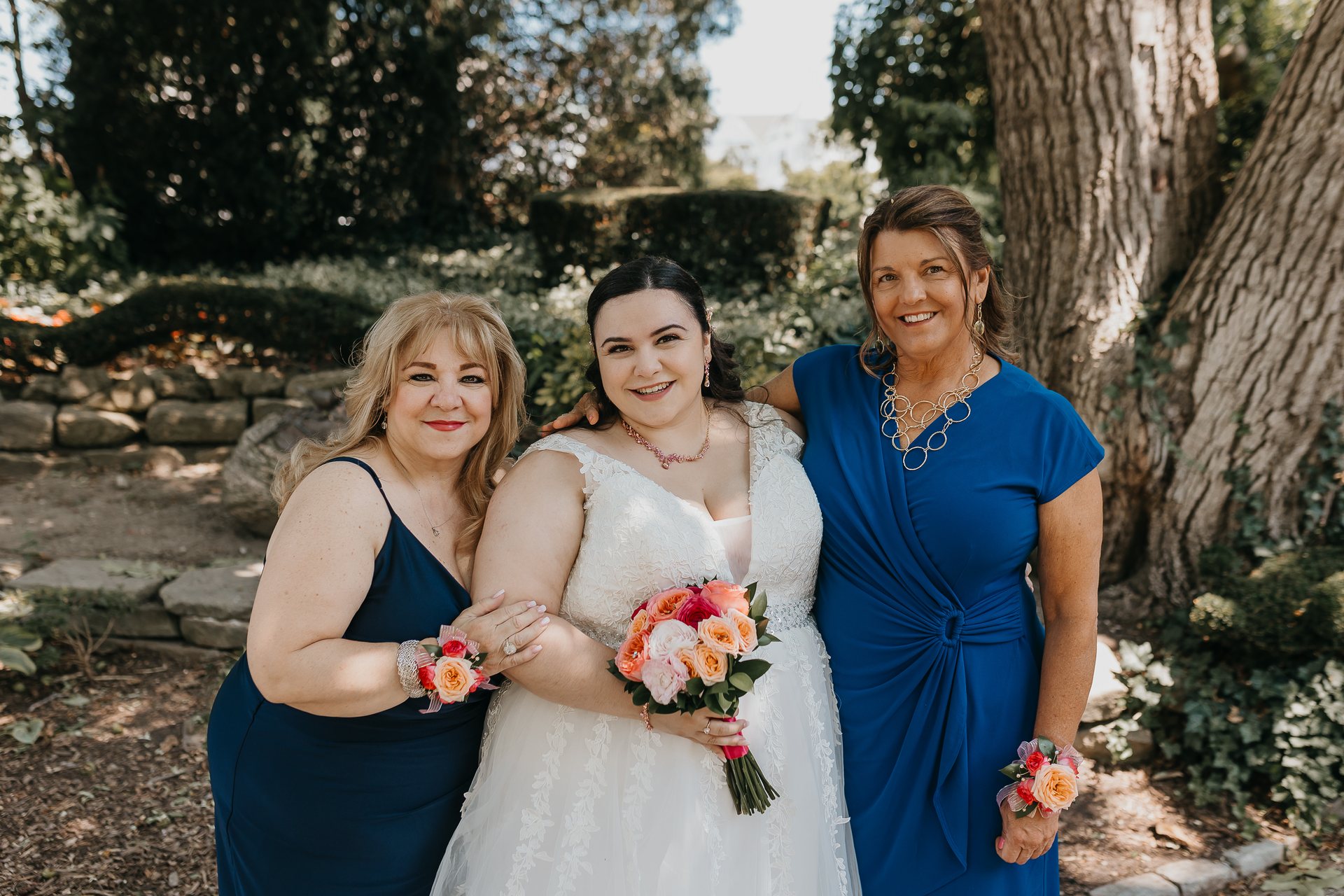 Chelsie posing with two family members in blue dresses