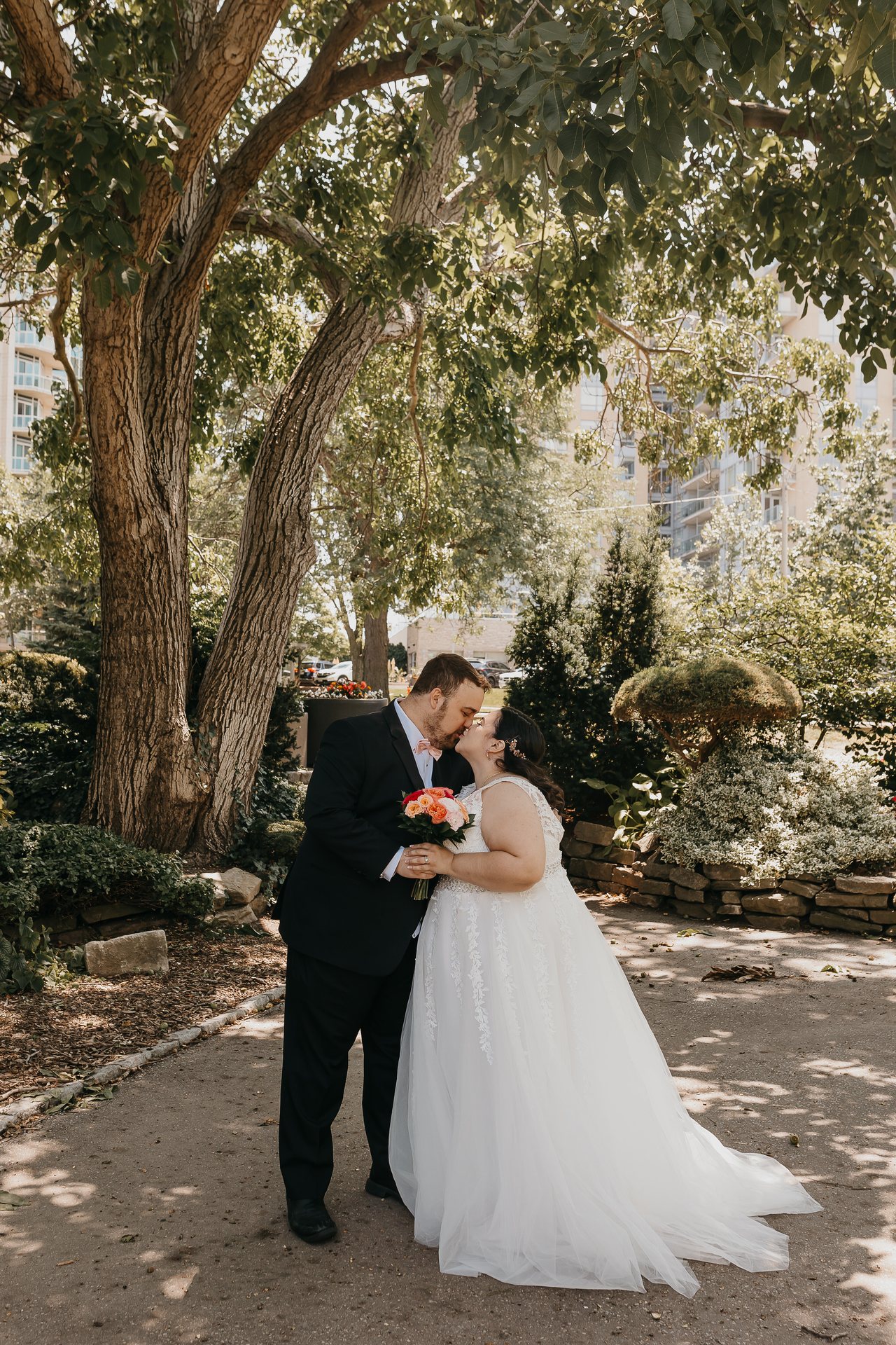 Chelsie and Greg standing together under the trees