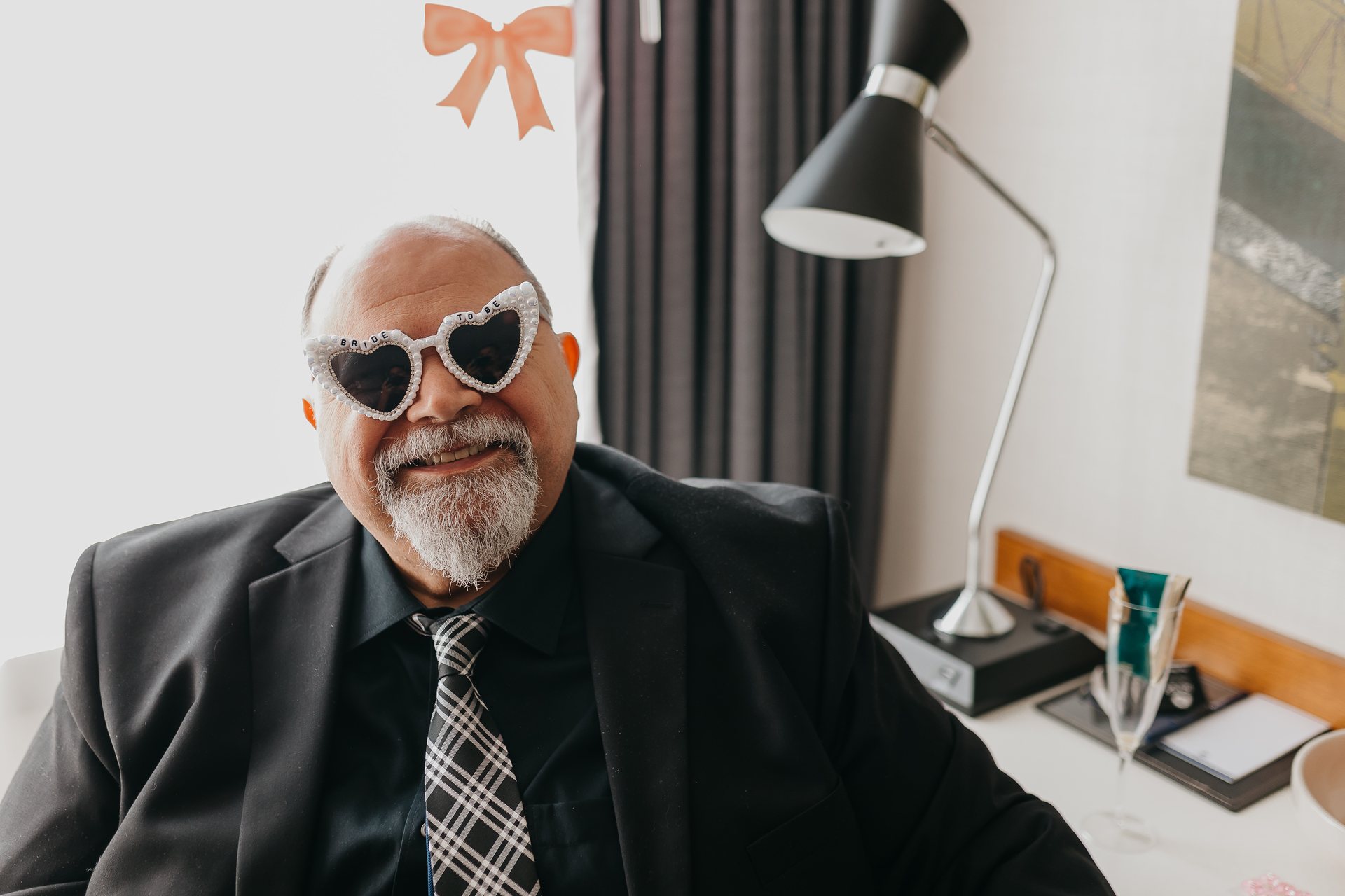 Greg smiling in bride-to-be sunglasses while getting ready