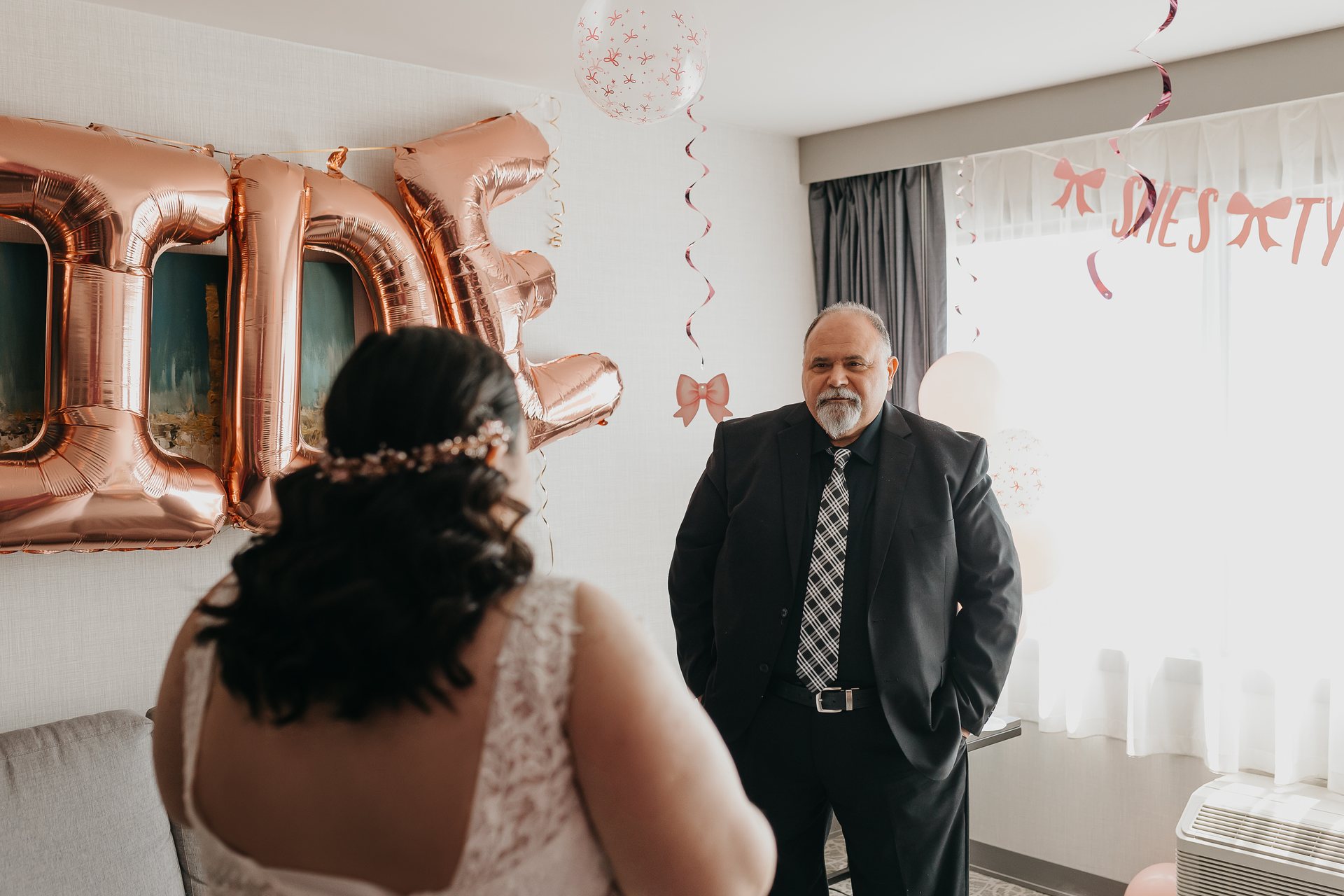 Chelsie and Greg sharing a getting-ready moment near bride balloons