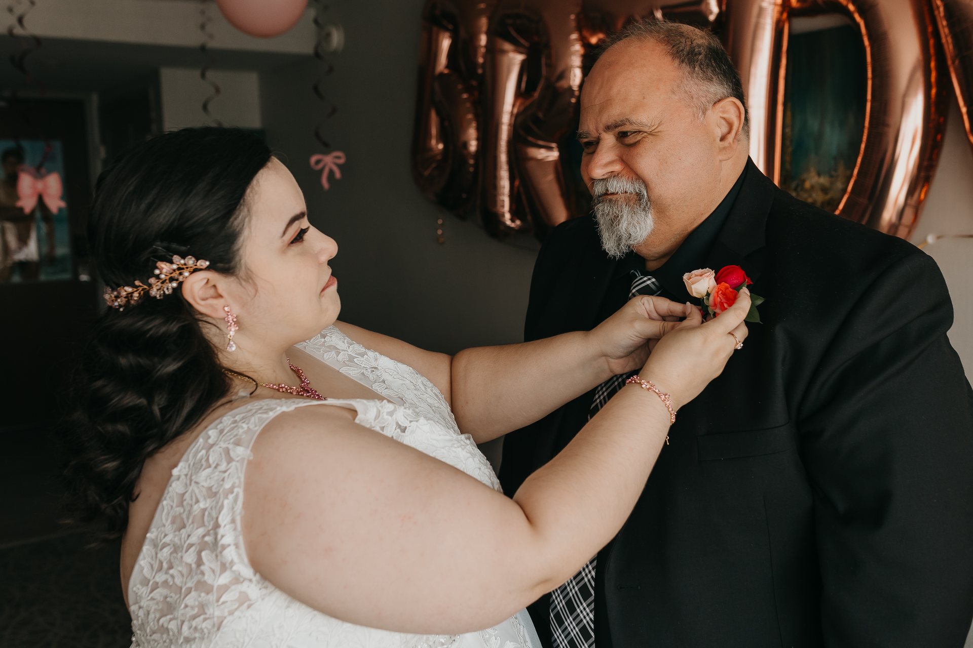 Chelsie pinning a boutonniere on Greg